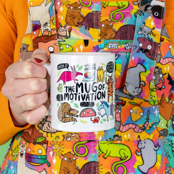 A white ceramic mug with lots of Katie Abey fun illustrations on telling you that you can do it. Text says the Mug of Motivation