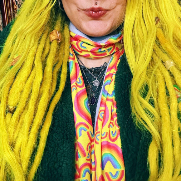 Katie wearing the Rainbow Jersey Circle Scarf.  The yellow scary has rainbow illustrations all over by Katie Abey