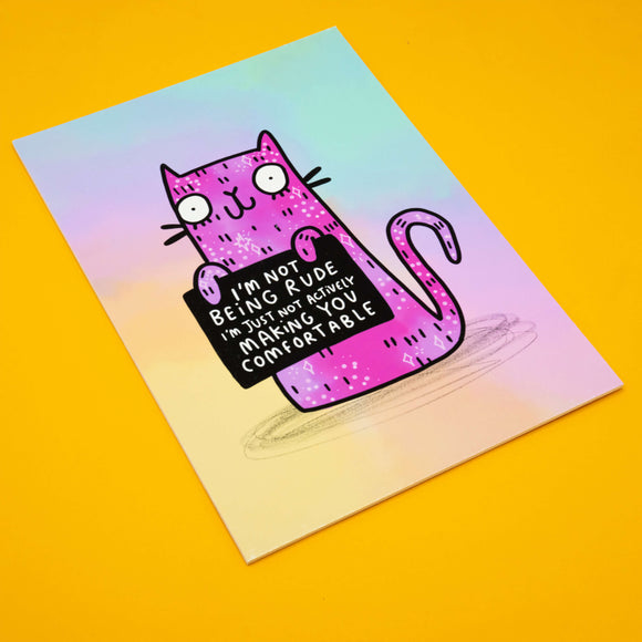 Katie Abey “I’m Not Being Rude” Cat Art Print on a bright yellow background. The quirky pink illustrated cat holds a black sign with the words “I’m not being rude, I’m just not actively making you comfortable.” A fun, sassy A4 print with a matte finish, perfect for cat lovers, weird art fans, and bold home décor.