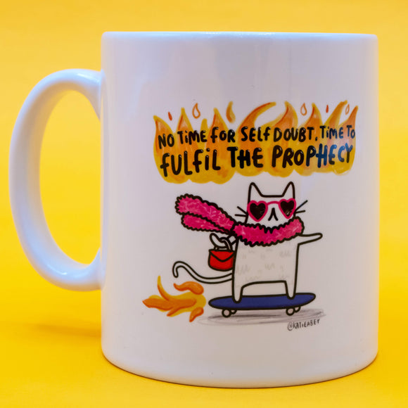 White ceramic mug with a colourful Katie Abey illustration of a cat in sunglasses, feather boa and roller skates, riding a skateboard under the slogan “No time for self doubt, time to fulfil the prophecy.” Bright yellow background.