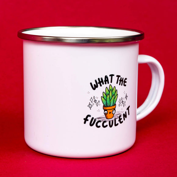 What The Fucculent Enamel Mug sat in front of a red backdrop. The white mug with silver brim has an illustration of a green succulent in a pot with a twitch in it's eye and down turned mouth. Sparkles are drawn either side of the succulent. The text on the mug reads what the fucculent. Designed by Katie Abey in the UK.