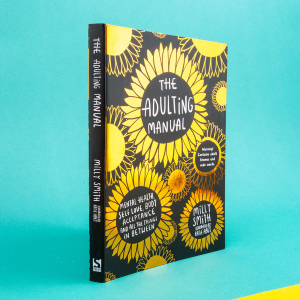 front cover of the Adulting Manual by Milly Smith illustrated by Katie Abey. It has lots of gold shiny flowers on a black background