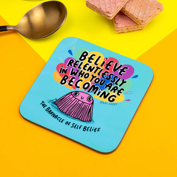 blue coaster with an illustration of a barnacle by Katie Abey with Believe relentlessly in who you are becoming written on the top and The Barnacle of self Belief written underneath.