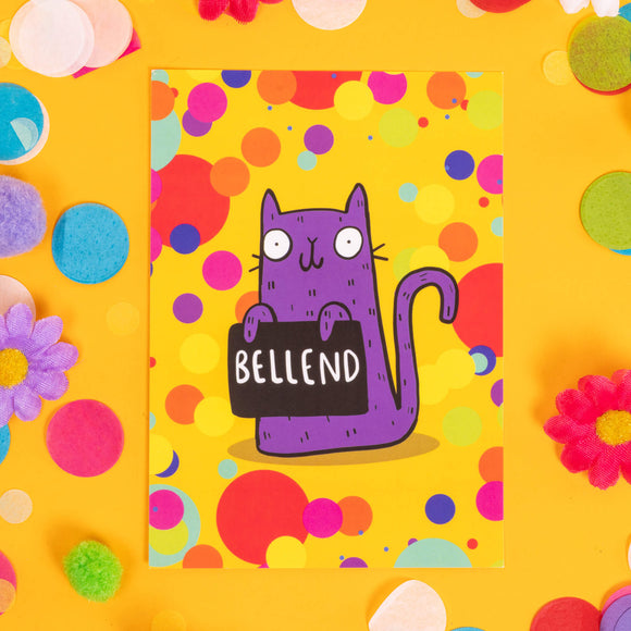 Purple and cat on a yellow background with colourful circles it is printed A6 greetings postcard with smiley face holding sweary rude sign by Katie abey resting on a yellow background with confetti, fake daisies, pom poms.