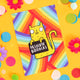 The Sweary Cat Absolute B*llocks A6 Postcard in front of a yellow backdrop with colourful flower and confetti decorations. The rainbow striped postcard has an illustration of a yellow smiling cat on the front holding a black sign with white text that reads absolute bollocks. Designed by Katie Abey in the UK.