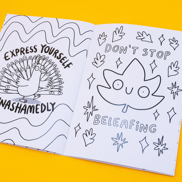 Open spread of the Stay Whimsical colouring book. One side shows a peacock with the caption “Express yourself unashamedly.” The other page features a happy cartoon leaf with the phrase “Don’t stop beleafing.” Both illustrations are in bold line art with playful and positive messages, ready to be coloured in.