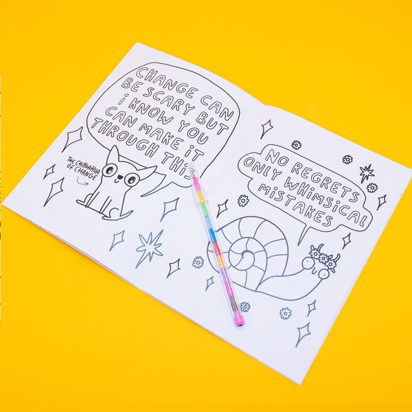 Open spread of the Stay Whimsical colouring book. One side shows the Chihuahua of Change saying, “Change can be scary but I know you can make it through this.” The opposite page has a cheerful snail with the phrase “No regrets, only whimsical mistakes.” A rainbow pen lies across the book. Full of uplifting affirmations and quirky characters.