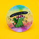 Round vinyl sticker featuring a green dragon wearing a red toadstool hat with white spots, sitting peacefully with sparkles around. Above the dragon is the phrase “Connected to My Awe” in bold hand-lettered text. Set against a dreamy rainbow pastel background. Approx. 8cm wide. A joyful and uplifting sticker by Katie Abey, perfect for spreading magical vibes and positive weirdness.