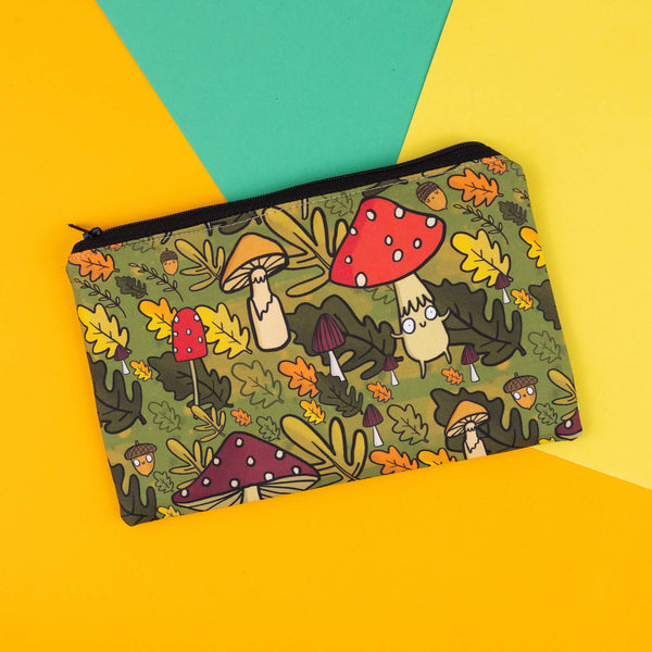 Back view of the mushroom bois pencil case of cute illustrated mushroom characters, with pops of red from toadstools and green foliage, making it a whimsical and functional accessory. Great for storing stationery or makeup and handmade by Dawny’s Sewing Room. The autumnal-themed design with acorns and leaves adds a touch of fun to any collection, perfect for nature lovers and anyone who enjoys embracing their weirdness.