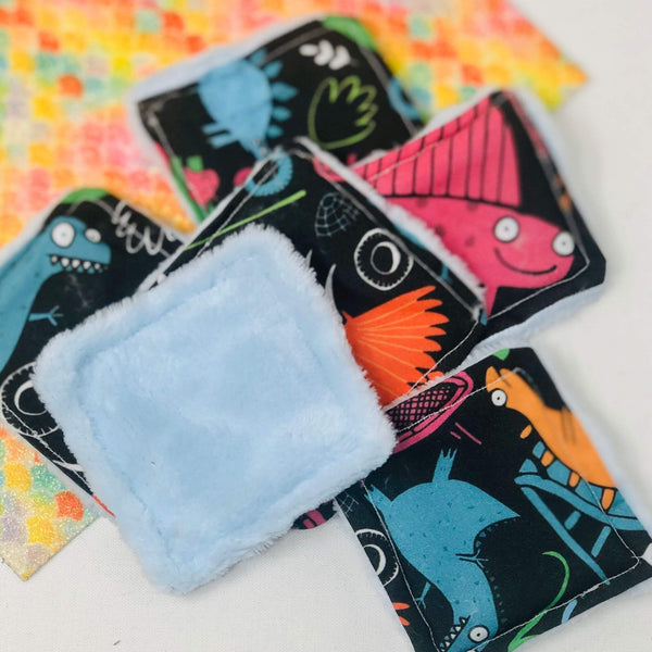 black Reusable Makeup Remover Pads with colourful Katie Abey illustrations on. The other side of the pad is plain white