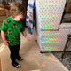 A child looking at the rainbows cast by the sun catcher on a chair in a living room