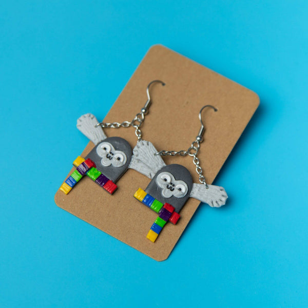 Grey mixed clay marmoset drop earrings wearing colourful scarf, with hypoallergenic silver hook and chain. Eco friendly packaging. Designed and handmade in the UK by Katie Abey