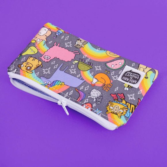 The Positivity Print Coin Purse on a purple background. The light grey purse has Katie Abey character illustrations all over