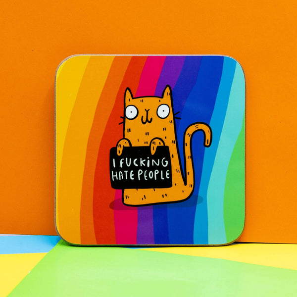 I F*ing Hate People Sweary Cat square coffee tea coaster. Rainbow background featuring orange illustrated smiley cat holding black sign. Designed by Katie Abey in the UK
