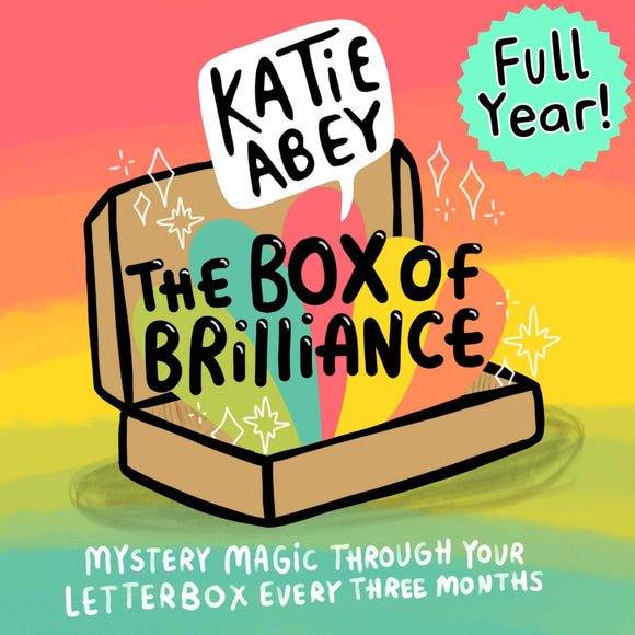 The Katie Abey box of brilliance subscription mystery box. Illustrated brown cardboard box sat open on a rainbow background with rainbows and white sparkles bursting out and text reading 'the box of brilliance' with the Katie Abey logo and 'Full Year!' above. Bottom text reads 'Mystery magic through your letterbox every three months'.