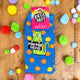 Blue socks on wooden background with fluffy rainbow balls sprinkled around. The blue socks have orange and yellow polka dots. Socks have lime greet cat illustration holding a black sign with 'poo poo head' written on in white letters.