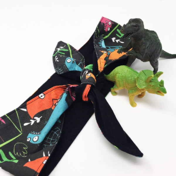 a grey hair tie with illustrations of dinosaurs by Katie Abey and Dawney's sewing room