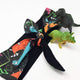 a grey hair tie with illustrations of dinosaurs by Katie Abey and Dawney's sewing room
