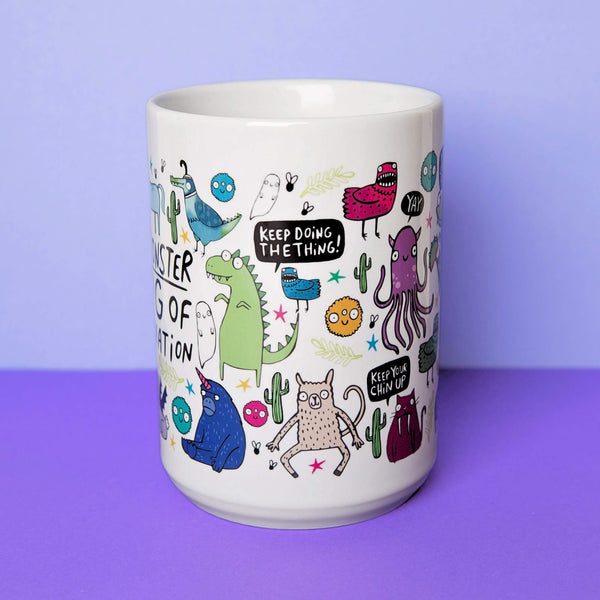 A white mug designed by Katie Abey featuring a delightful mix of quirky monsters and uplifting quotes, such as "Keep doing the thing!" and "Keep your chin up," with a lavender background highlighting the playful design.