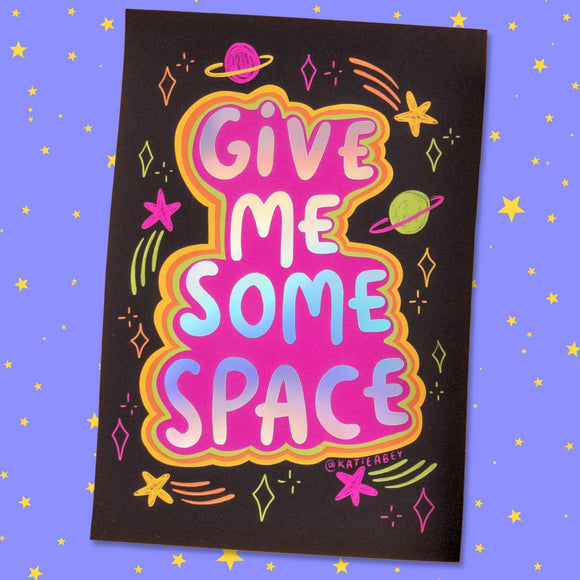 Colourful illustrated poster by Katie Abey featuring the phrase "Give Me Some Space" in bold, gradient letters. The text is surrounded by vibrant space-themed elements, including planets, stars, comets, and abstract shapes. The background is black, which makes the neon colours pop, and the overall design is playful and whimsical. The artist's handle, @katieabey, is visible at the bottom right corner. The poster is set against a purple background with a pattern of yellow stars, adding to the cosmic theme.