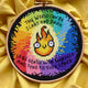 Bright rainbow cross stitch design photographed on yellow fabric, with flame illustration in the middle and embroidered inspirational message surrounding it.