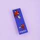 Deadpool Readpool bookmark laying face up on a pastel purple background. The bookmark is laser printed card with a blue background and two deadpool characters smiling reading books with bottom text reading 'Readpool'. Designed by Katie Abey in the UK and printed with a silk finish so they are wipe clean.