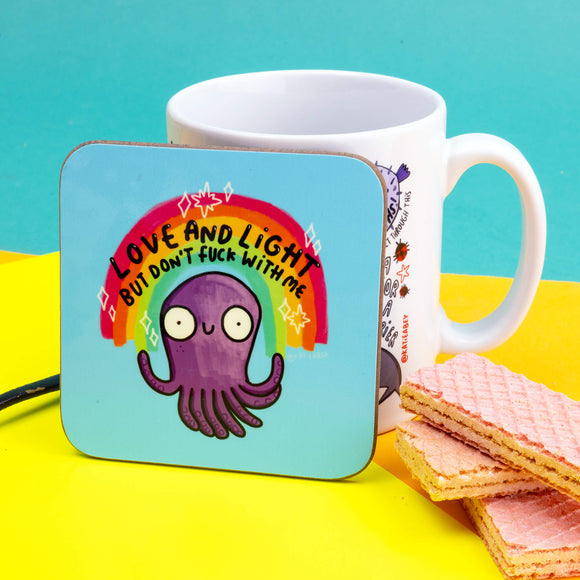 Love and Light but don't fuck with me circular pale blue square coffee tea coaster, featuring purple smiley octopus with rainbow and stars, and black writing. Designed by Katie Abey in the UK