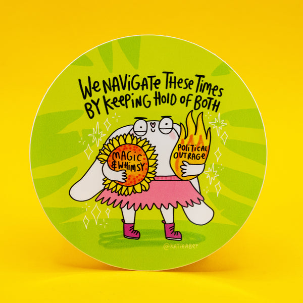 Bright green pattern circle vinyl sticker illustrated by Katie Abey featuring a cute white bunny character holding a sunflower reading 'magic and whimsy' and a flaming heart reading 'political outrage'. Handwritten text reads 'we navigate these times by keeping hold of both'. Bold, playful rabbit illustration with sparkles, pink skirt and boots, celebrating balance, feelings and being unapologetically whimsical.