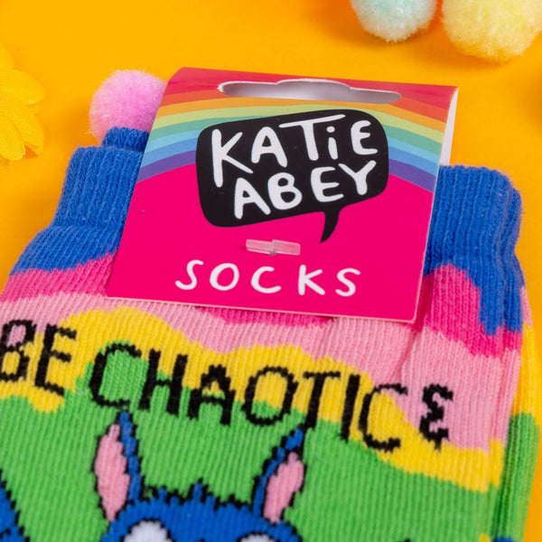 Close up of pink label with Katie Abey logo on the Be Chaotic & Unpredictable Rainbow Bat Socks