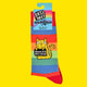 Katie Abey's "Absolute Bollocks" socks, packaged with a rainbow-striped label. The design features a rainbow background and a cheeky yellow cat, making them a playful and colourful gift for anyone who loves unique and fun accessories.