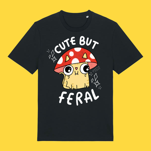 Black unisex adults t shirt featuring the Cute But Feral Cat artwork by Katie Abey. Illustrated cat wearing a red spotted mushroom hat with bold white Cute But Feral text. Quirky graphic tee for cat lovers and alternative fashion fans.
