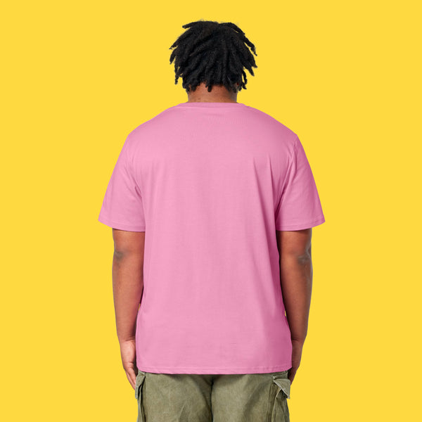 Model wearing the bubble pink Cute But Feral Cat adults t shirt shown from the back. Loose fitting organic cotton tee with a casual drape, styled with green cargo trousers on a yellow background.