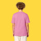 Model wearing the bubble pink Cute But Feral Cat adults t shirt shown from the back. Relaxed unisex fit with short sleeves and crew neck, styled with light trousers against a yellow background.