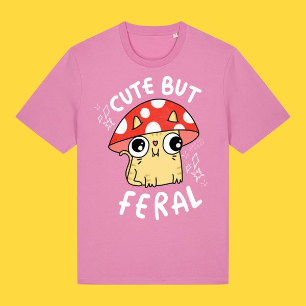 Bubble pink unisex t shirt featuring the Cute But Feral Cat artwork by Katie Abey. Illustrated cat in a red spotted mushroom hat with Cute But Feral text. Fun, colourful graphic tee for adults.