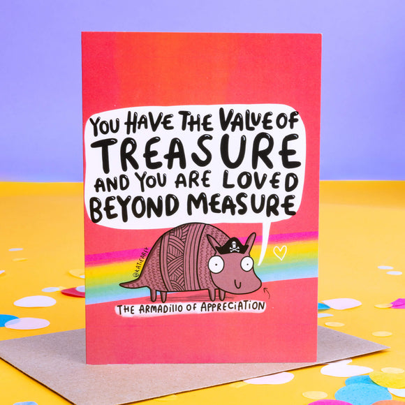 A pink greeting card with purple, yellow and blue stripes and a pink armadillo illustration with a little pirate hat on it's head with a speech bubble coming from it's mouth that reads 'you have the value of treasure and you are loved beyond measure. 'The Armadillo of Appreciation' is written under the illustration with an arrow pointing up towards it.