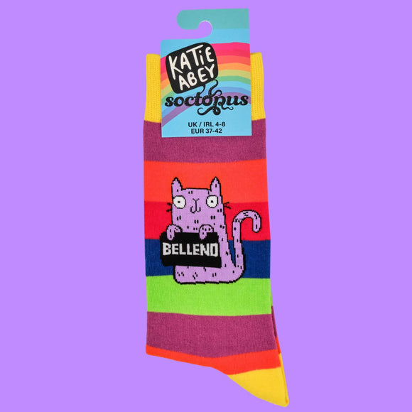 Katie Abey rainbow striped socks in packaging, showcasing the unique purple cat character holding a "Bellend" sign. A fun and eccentric small business design perfect for quirky, colourful gift ideas or personal style statements. UK size 4-8 with a playful twist.