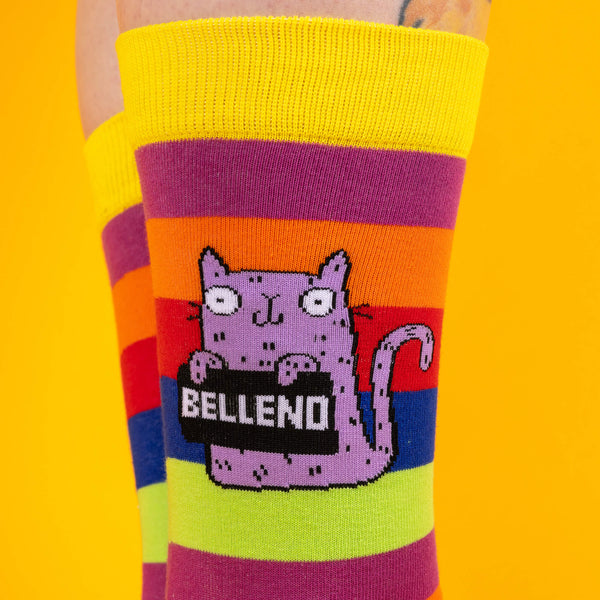 A close-up of the purple cat design on the socks, showing its cheeky expression and Bellend slogan, surrounded by colourful stripes.