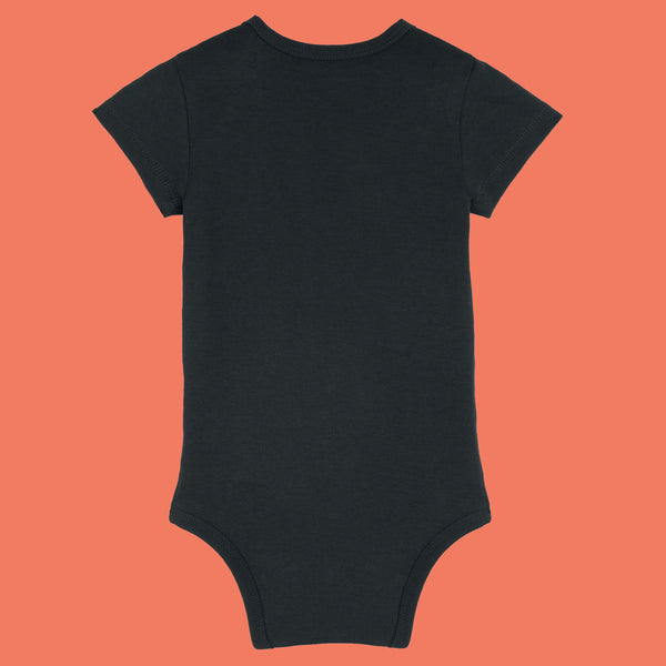 Black organic cotton baby bodysuit by Katie Abey shown from the back. Soft short sleeve babygrow with popper fastening and comfortable interlock cotton fabric. Stylish alternative baby clothing designed by a UK illustrator known for encouraging everyone to be proudly weird.
