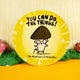 Quirky circular sticker by Katie Abey showcasing the "Mushroom of Motivation" illustration with a dark brown cap, rosy-cheeked face, and fun text that says "You Can Do The Things!" in bold black. The yellow background with sparkles exudes encouragement and charm, set against a whimsical woodland-inspired backdrop.