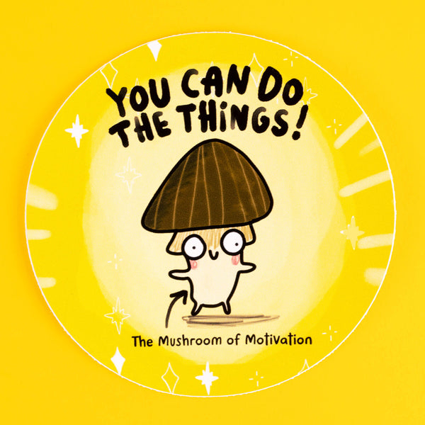 A motivational circular sticker featuring a cheerful illustrated mushroom with a dark brown cap, quirky eyes, and rosy cheeks, paired with the uplifting text "You Can Do The Things!" in bold black letters. Below, it reads "The Mushroom of Motivation." Designed by Katie Abey, this sticker combines humour and positivity to inspire. The yellow background is adorned with sparkles, radiating good vibes. Perfect for decorating laptops, notebooks, or anywhere needing a boost of encouragement.