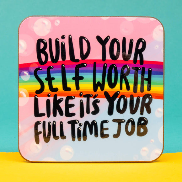 A Katie Abey illustrated coaster on a pastel blue and pink bubbly background with a rainbow running through. Over the top text says, Build your self worth likes its your full time job