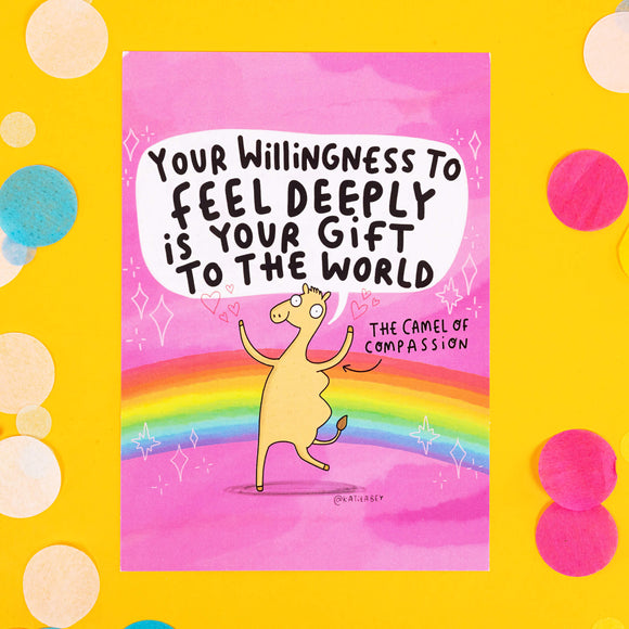 A pink and rainbow postcard  with a dancing camel drawn by Katie Abey with the quote 'YOUR WILLINGNESS TO FEEL DEEPLY IS YOUR GIFT TO THE WORLD' it also has an arrow pointing at the camel with 'The Camel of Compassion' 