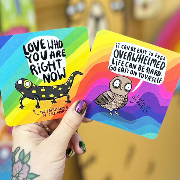 Square cards with magical messages, featuring illustrated black and yellow polka dot salamander of self worth, with speech bubble that reads 'Love who you are right now' and The Owl of Overwhelm that reads 'it can be easy to feel overwhelmed life can be hard. Go easy on yourself.' Designed by Katie Abey in the UK