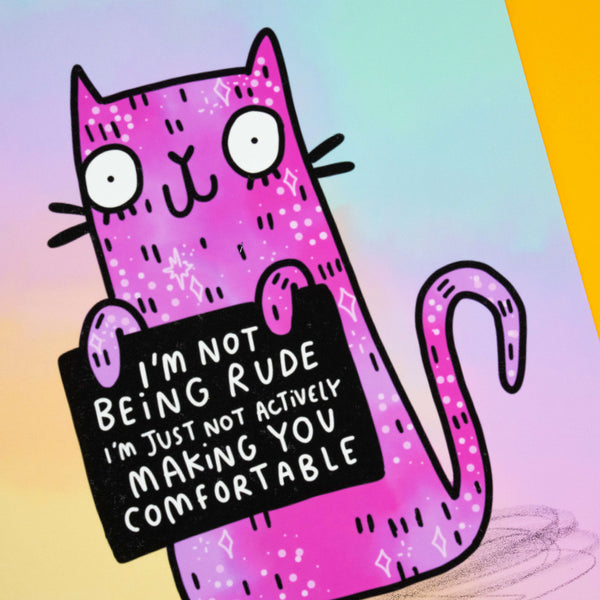 Close-up of Katie Abey’s “I’m Not Being Rude” Cat Art Print featuring a pink cartoon cat with quirky doodle details. The cat holds a sign saying, “I’m not being rude, I’m just not actively making you comfortable.” A signed and numbered A4 matte print for fans of alternative art and playful illustration.