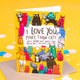 I love you more than cats a6 greeting card stood up on the brown envelope the card comes with, silver glittery paper and love hearts sweets on a white background. The card cover is a yellow background with various different coloured, patterned and sized cats with text in the top centre reading 'I love you more than cats. Well, maybe not quite that much but I do love you lots' Designed by Katie Abey in the UK.