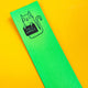 the top of a bright green leather bookmark with a black owtlined cat illustration by Katie Abey holding a sign saying cock Womble