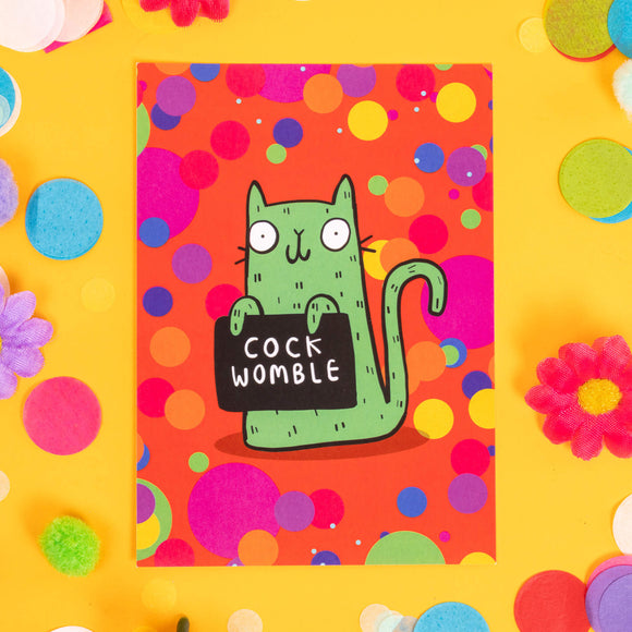Fun A6 greeting card postcard with green cat holding funny sweary sign and smiley face, on colourful background designed by Katie Abey in the UK. It is on a yellow background with confetti, fake daisies and pom poms.