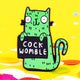 Green cat fridge magnet, smiley cat holding sign with funny sweary phrase cock womble. Green and black. Designed by Katie Abey in the UK