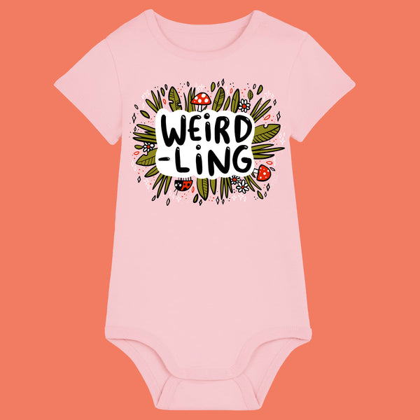 Cotton pink organic cotton baby bodysuit featuring the “Weird-Ling” design by Katie Abey. Playful illustration with mushrooms, foliage and bold lettering celebrating being weird and wonderful. Short sleeve baby grow with shoulder snap fastening and bottom poppers, ideal for quirky baby gifts and alternative baby clothes.
