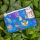 Crystal Critters coin purse in blue with illustrated spiders, daisies, pin needs and crystals